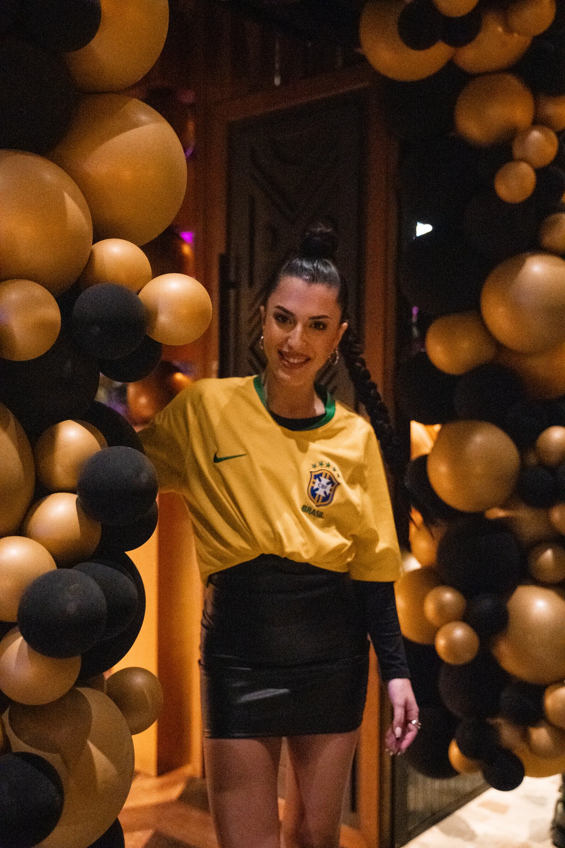 A guest among black and gold balloons at a birthday at Iguazu Athens