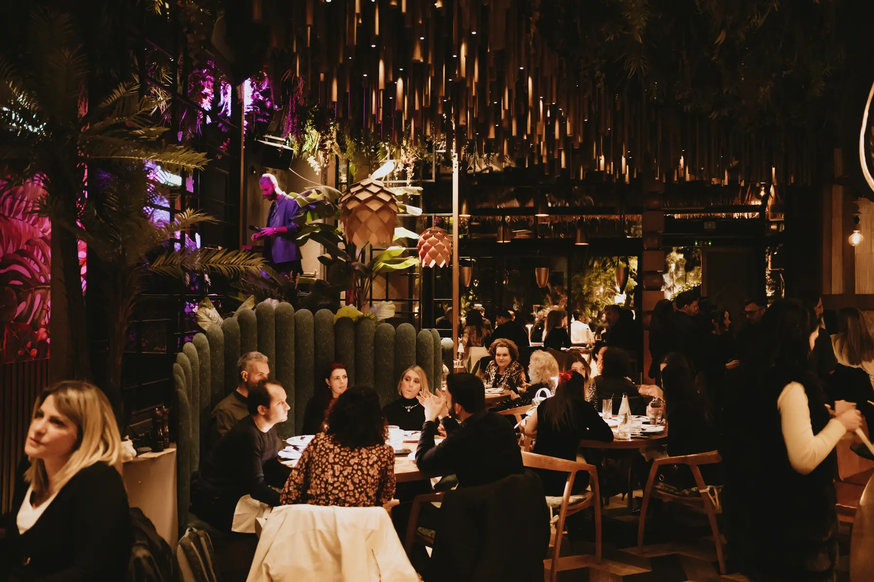 Long tables of guests under the hanging bamboo at a private dinner at Iguazu Athens