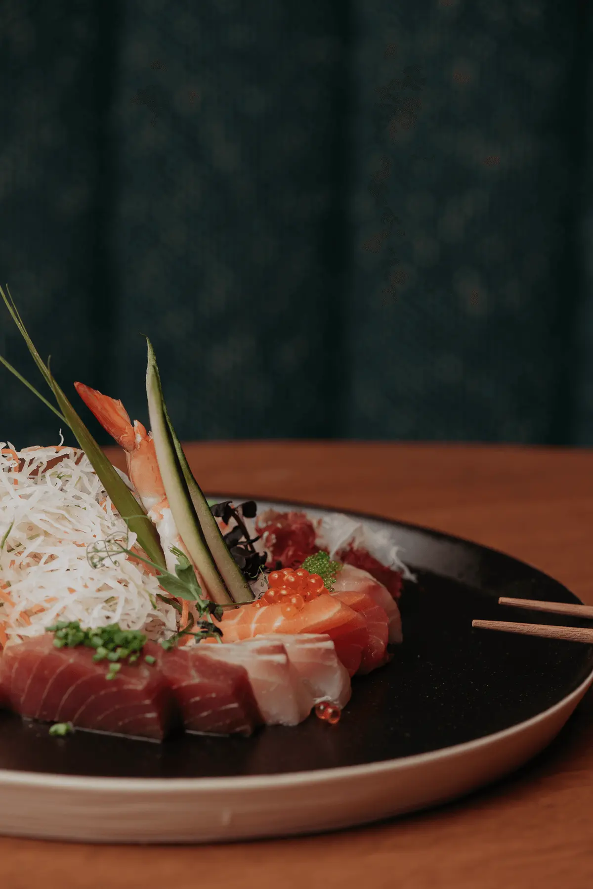 Sashimi plated with crisp shredded garnish and chopsticks
